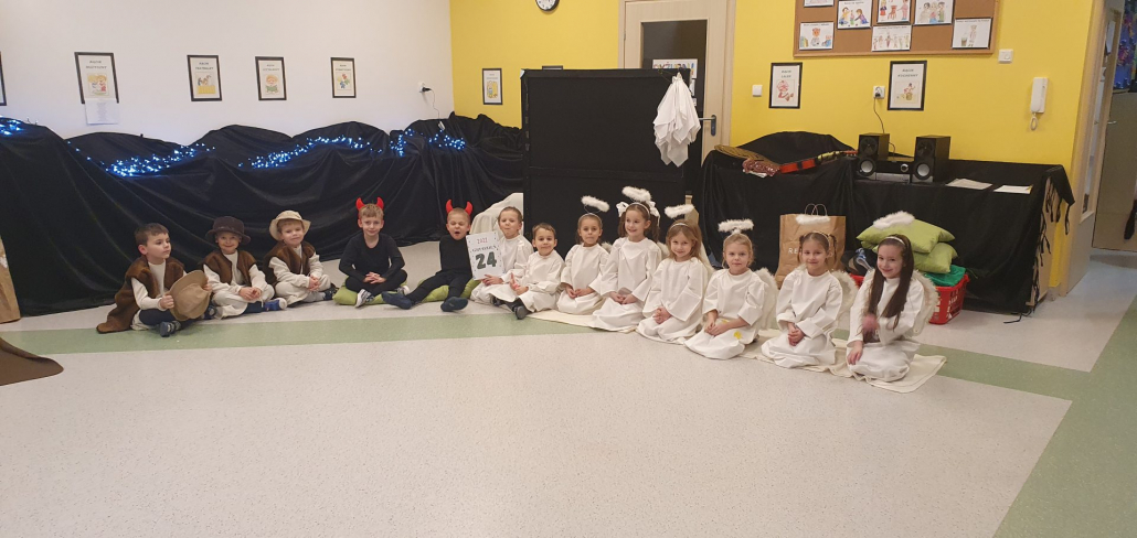 Zdjęcie przedstawia grupę dzieci w strojach aniołków, pastuszków oraz diabełków - inscenizacja Jasełek